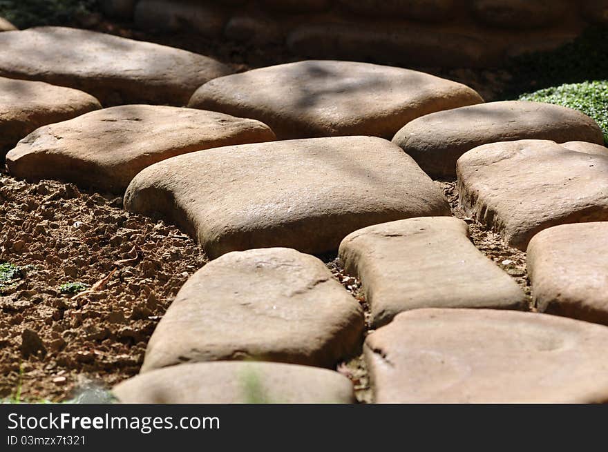 Big stones placed on the ground to form a curved pathway. Big stones placed on the ground to form a curved pathway