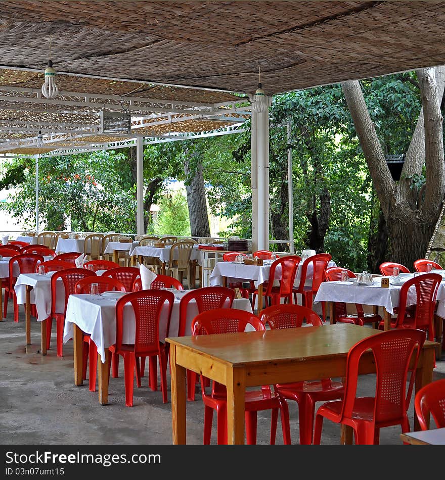 A Lebanese restaurant where the setting is of wooden tables and plastic chairs; shaded with woven hay. What is of importance is the natural surrounding. A Lebanese restaurant where the setting is of wooden tables and plastic chairs; shaded with woven hay. What is of importance is the natural surrounding