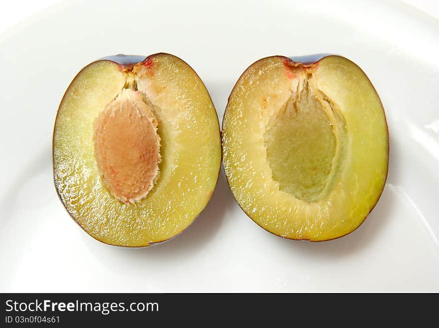 Ripe plums on porcelain plate