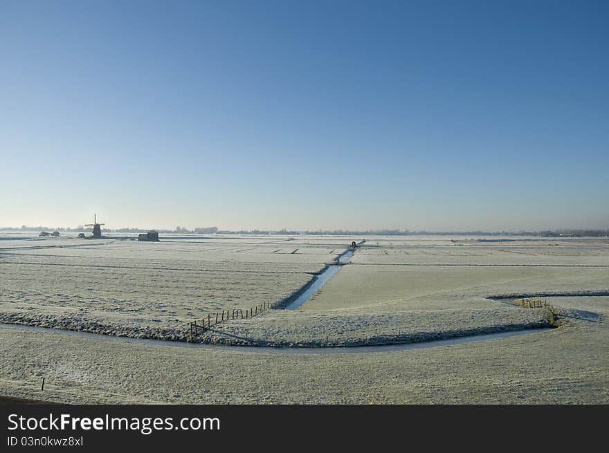 A windmill in a dutch winter landscape