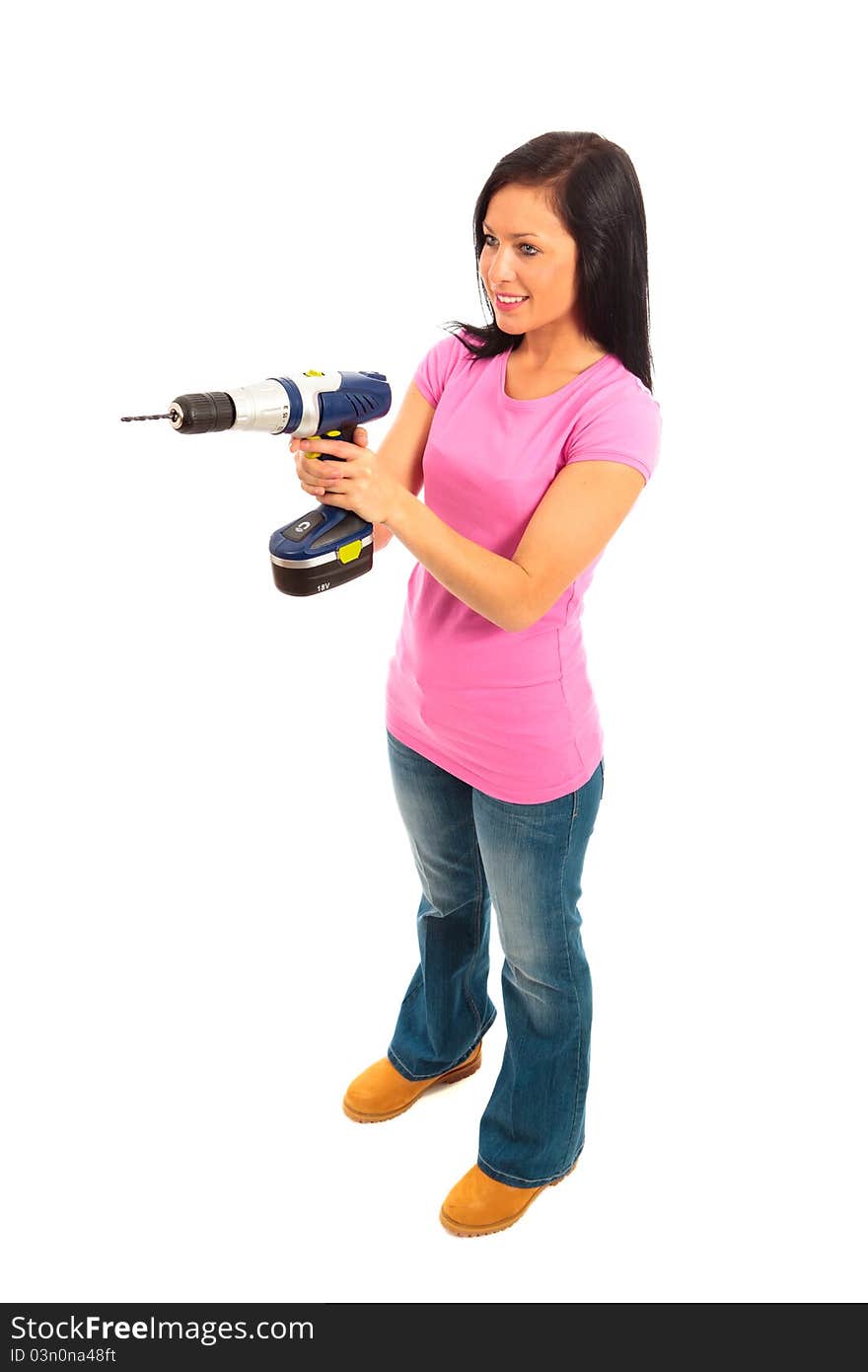 Young female dressed in pink top and blue jeans holding a cordless electric drill on isolated white background. Young female dressed in pink top and blue jeans holding a cordless electric drill on isolated white background.