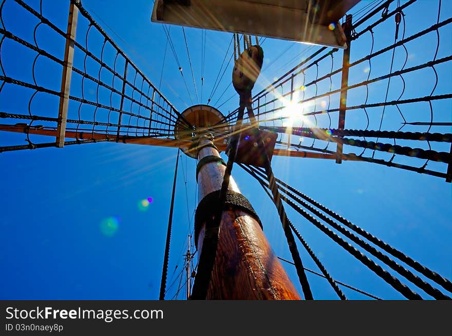 View of mast and rigging on the sail ship against the deep blue summer sky. View of mast and rigging on the sail ship against the deep blue summer sky.