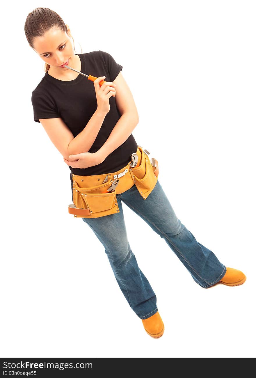 Young female dressed in black top blue jeans wearing a tool belt holding a screwdriver on a white isolated background. Young female dressed in black top blue jeans wearing a tool belt holding a screwdriver on a white isolated background