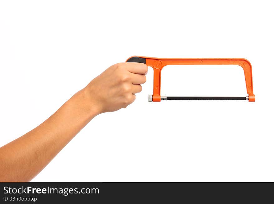 A female hand holding an orange hack saw on white isolated background