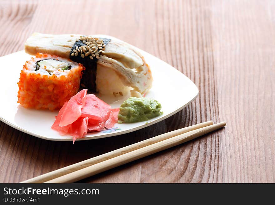 Japanese traditional cooked sushi and chopsticks on wooden surface. Japanese traditional cooked sushi and chopsticks on wooden surface