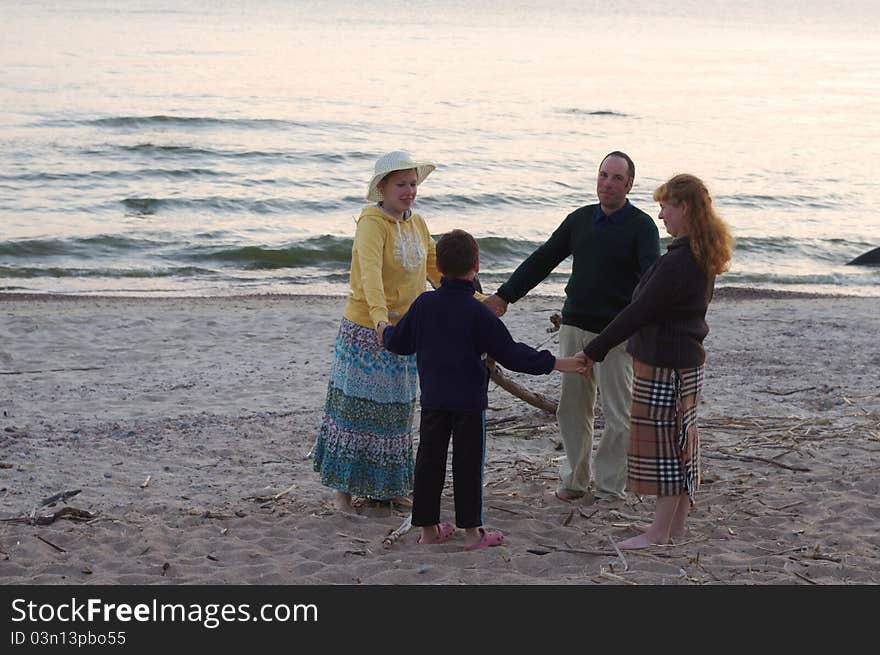 Family are playing on a beach in the evening time