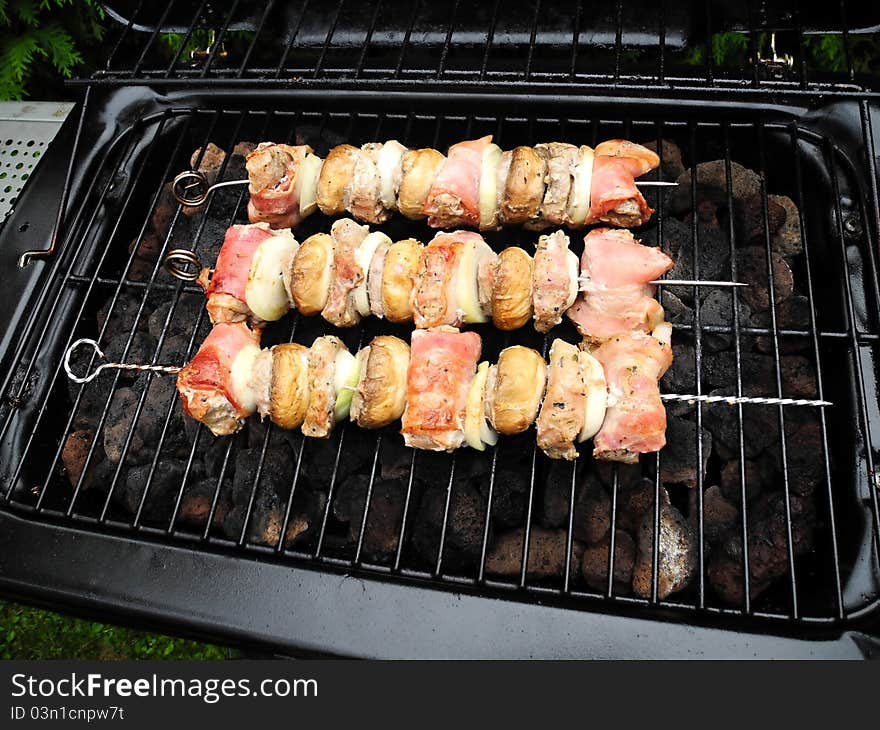 Grilling meat and mushrooms in the garden grill.