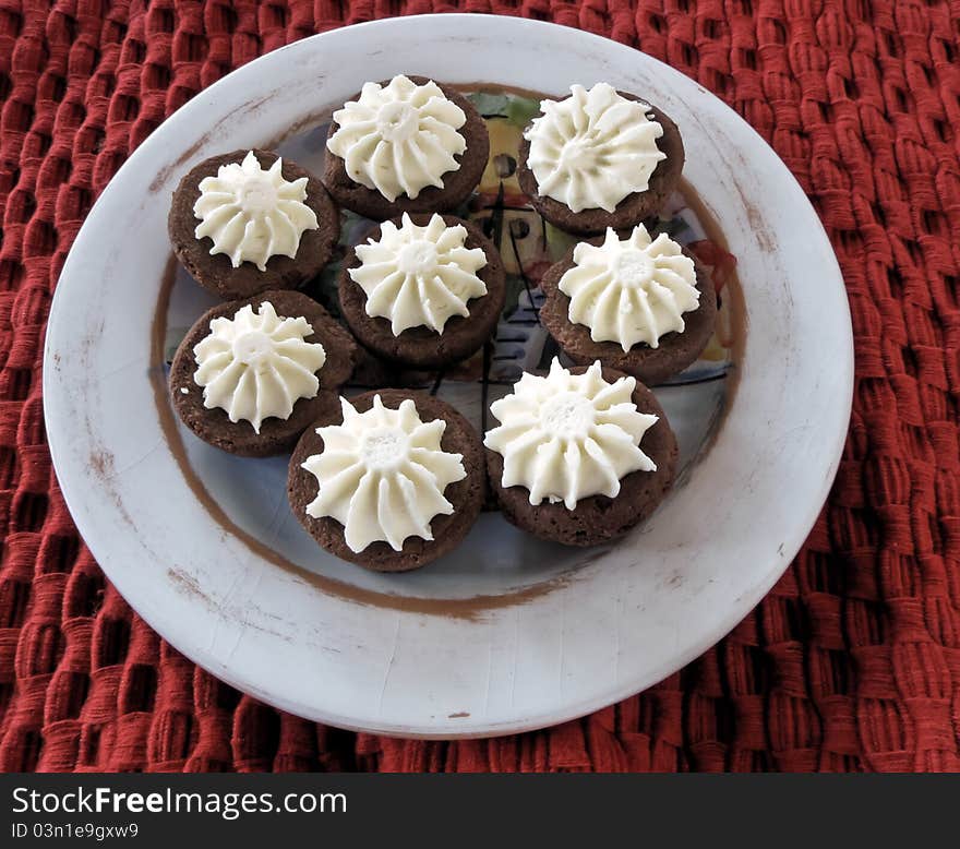 Individual size chocolate torts on painted pottery with a red handwoven textile. Individual size chocolate torts on painted pottery with a red handwoven textile