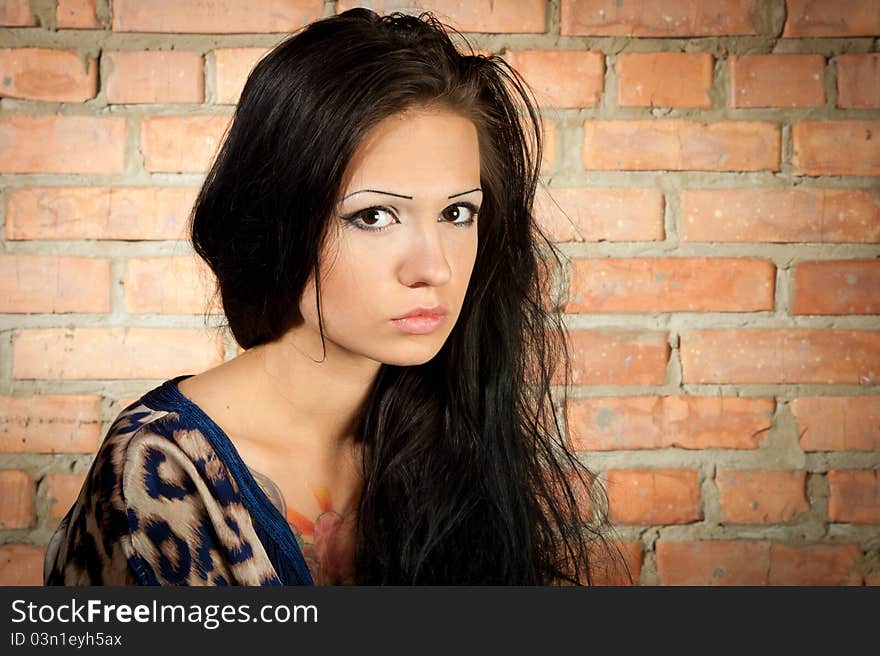 Brunet girl on the brickwall background