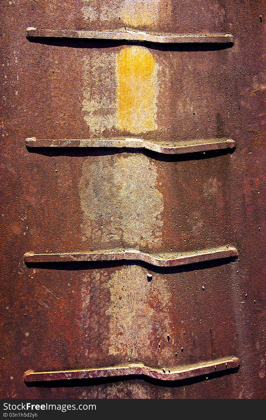 Some rusty piece of metal laying outdoors.