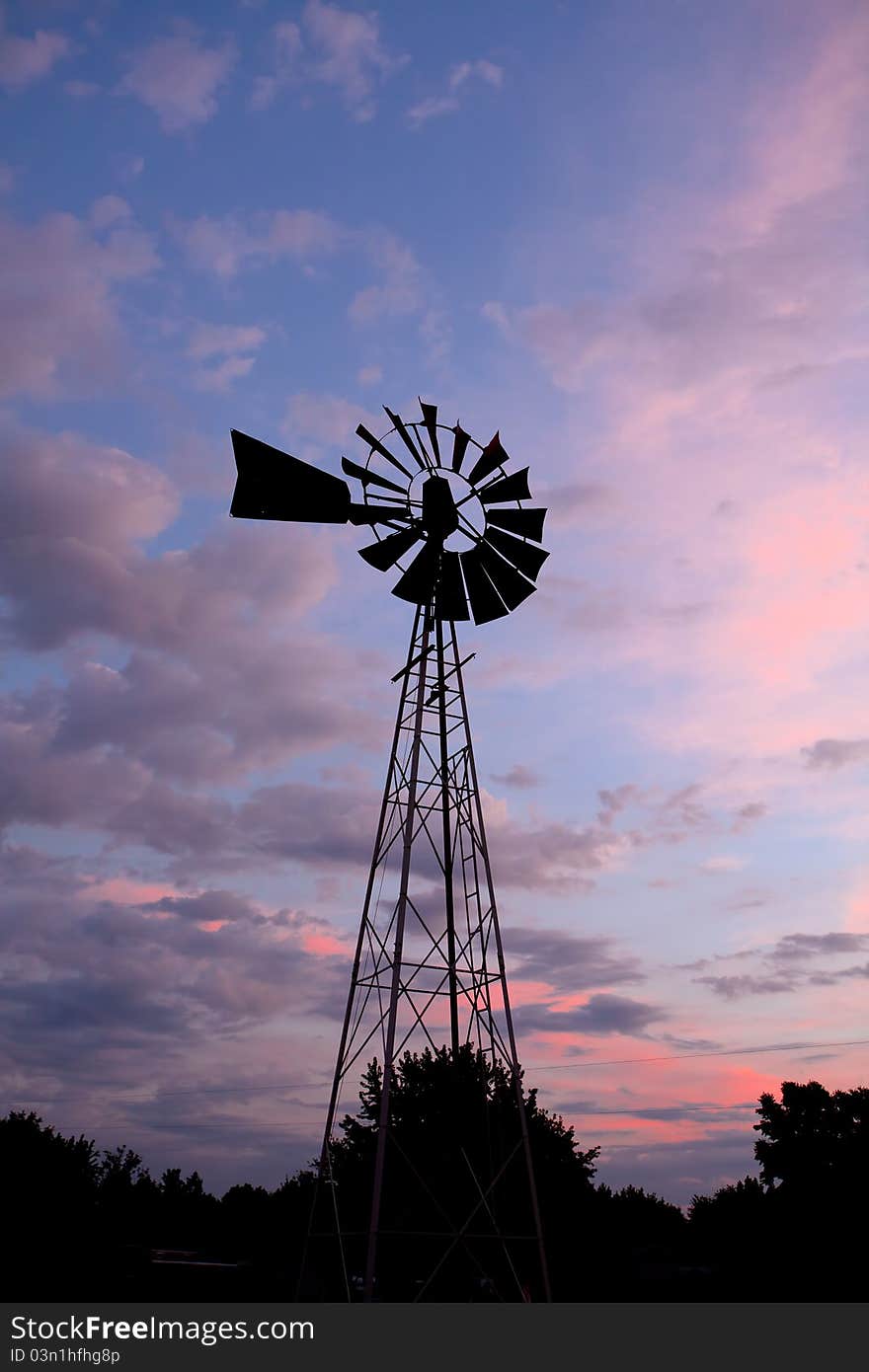 Old windmill in colorful sunset.