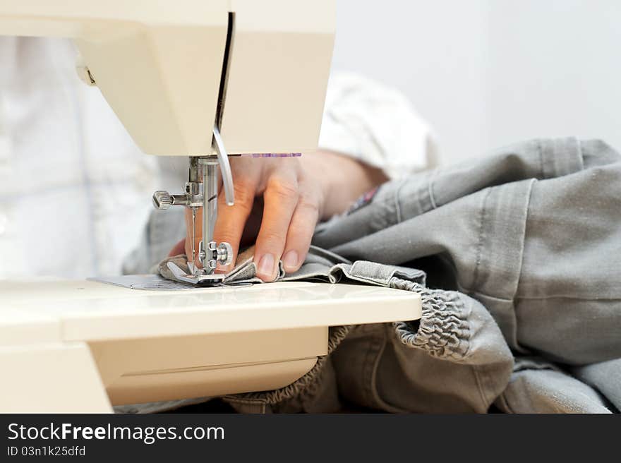 Female hand on an electric sewing machine. Female hand on an electric sewing machine