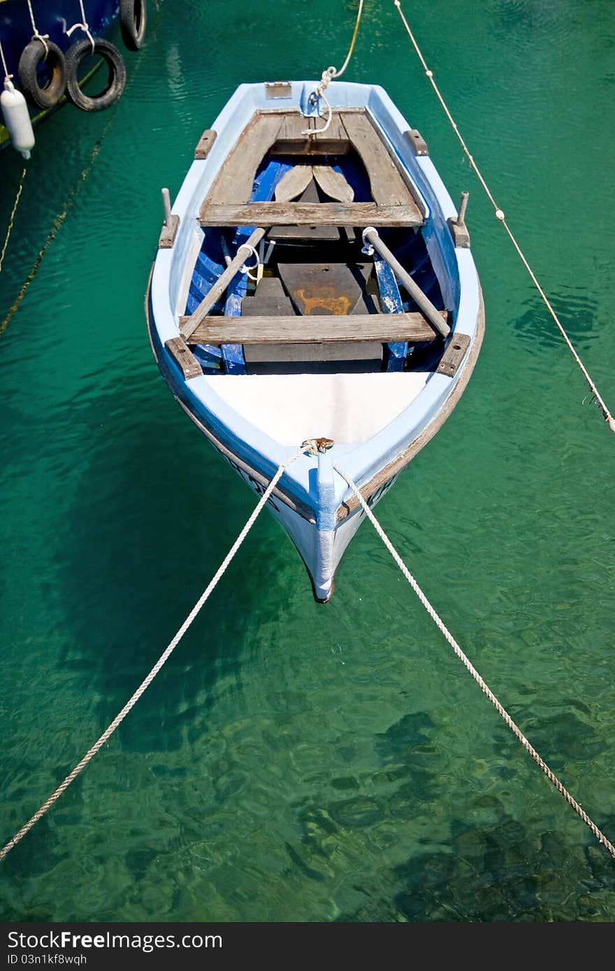 Old wooden fishing boat berthed in the crystal clear emerald waters of Jadranovo with the boat`s shadow on the seabed. Old wooden fishing boat berthed in the crystal clear emerald waters of Jadranovo with the boat`s shadow on the seabed