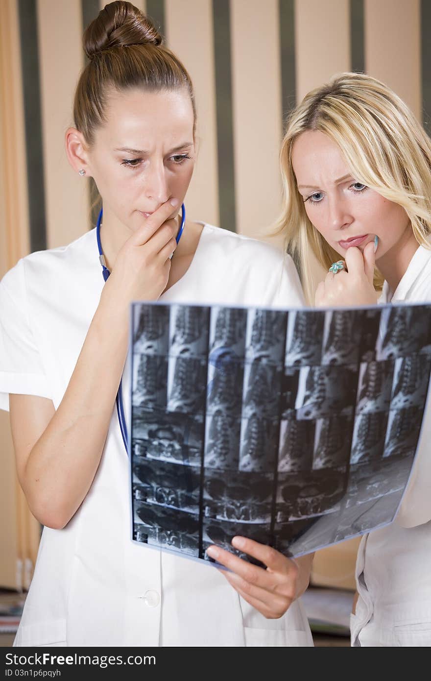 Women doctors reading radiology scans of patient spine. Women doctors reading radiology scans of patient spine