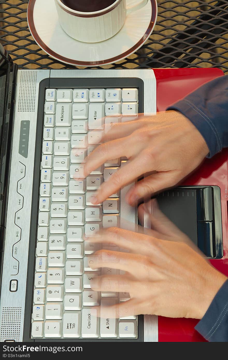 Close up of a woman's hands in motion typing on a red laptop. Close up of a woman's hands in motion typing on a red laptop.