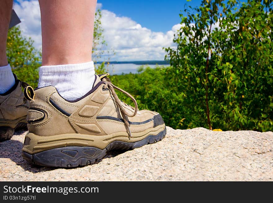 Closeup of a hikers rugged shoe as he stands on a rock looking at a natural landscape. Closeup of a hikers rugged shoe as he stands on a rock looking at a natural landscape