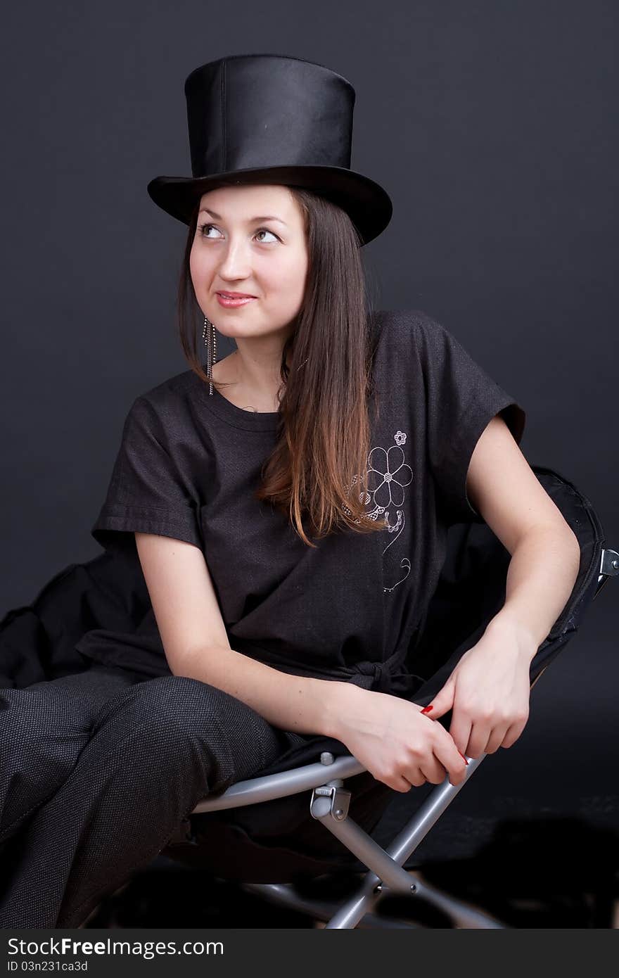 Beautiful smiling girl in a black hat on a dark background