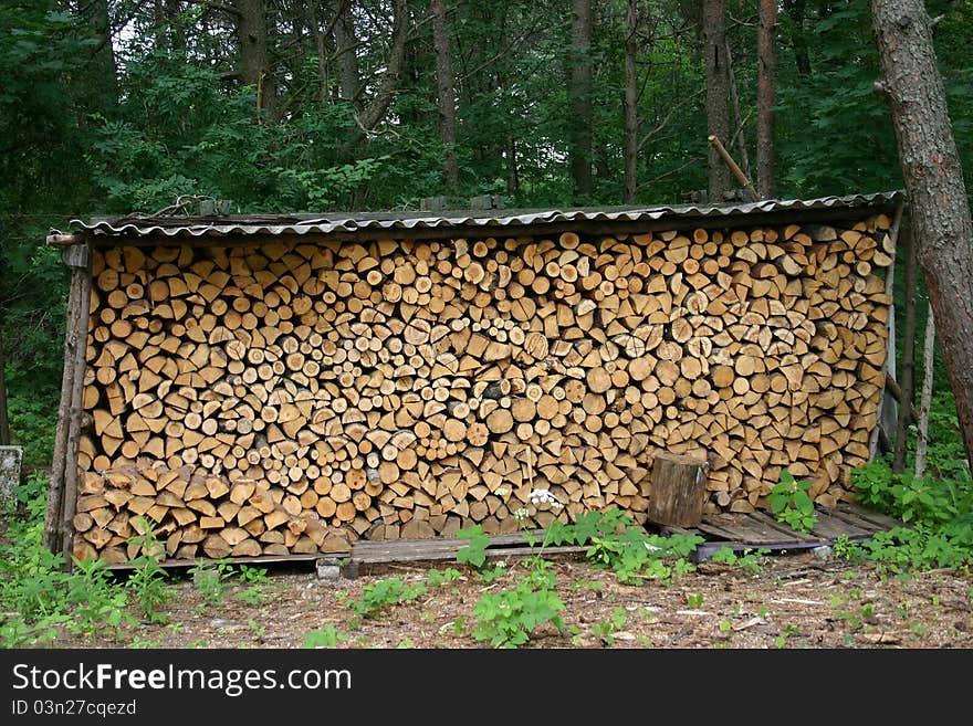 Firewood from a tree the brown Fire wood combined under a roof. Firewood from a tree the brown Fire wood combined under a roof