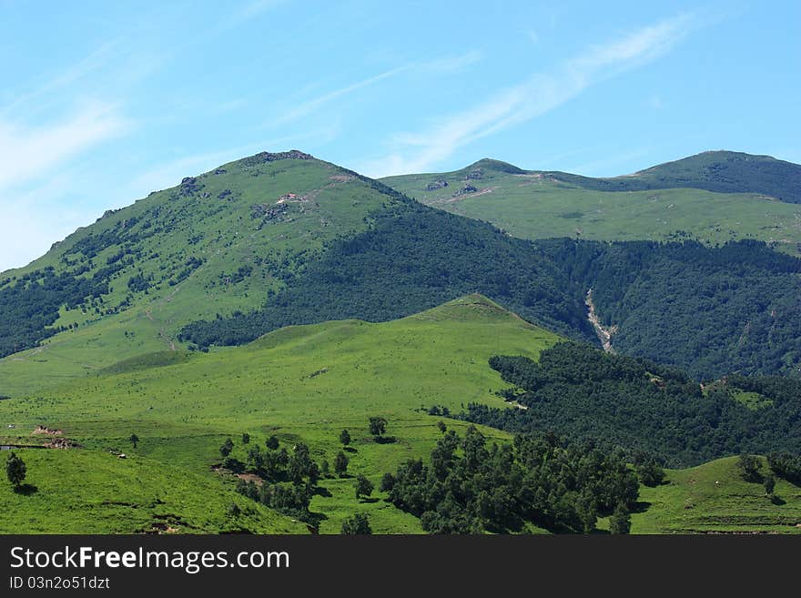 Green mountain with cloudy sky