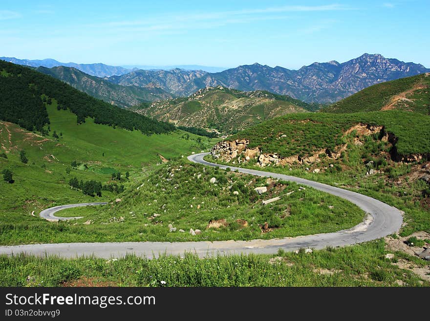 Green mountain with a road