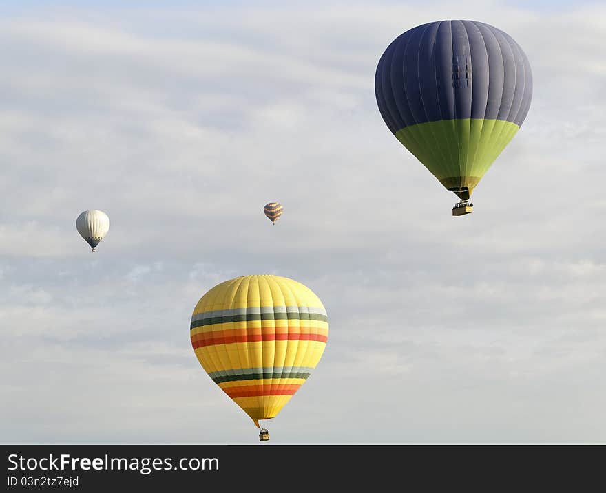 Four colorful balloons cloudy sky