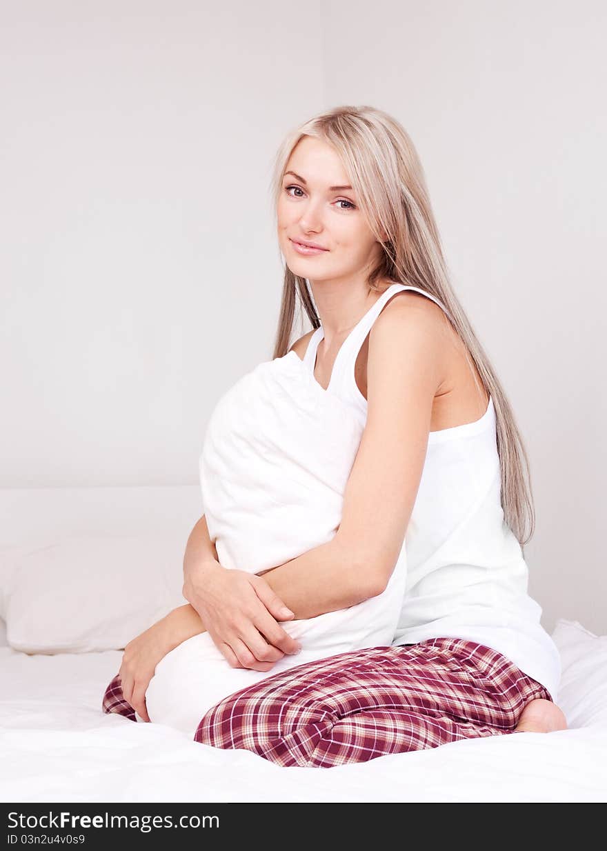 Beautiful young blond woman on the bed at home. Beautiful young blond woman on the bed at home