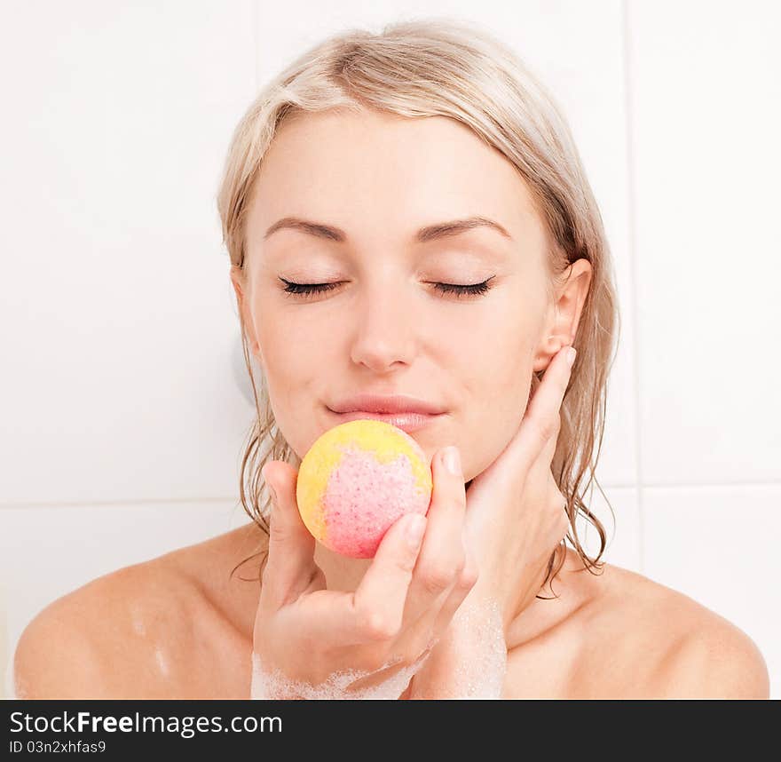 Beautiful young blond woman taking a bath and using an aromatized geyser