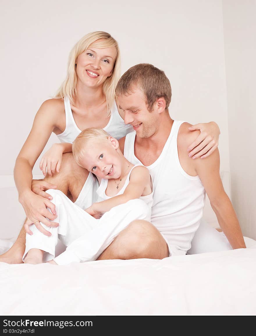 Happy family, mother ,father and their son on the bed at home. Happy family, mother ,father and their son on the bed at home