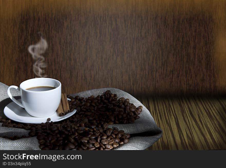 Cup of coffee and coffee beans on the Sacking, abstract grunge background. Cup of coffee and coffee beans on the Sacking, abstract grunge background