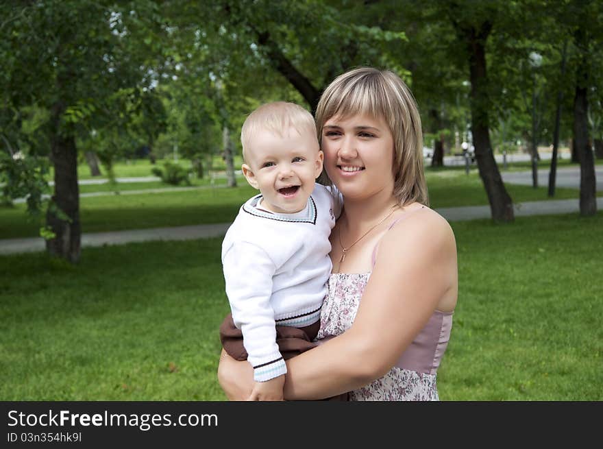 The portrait of the baby and mother in the park. The portrait of the baby and mother in the park