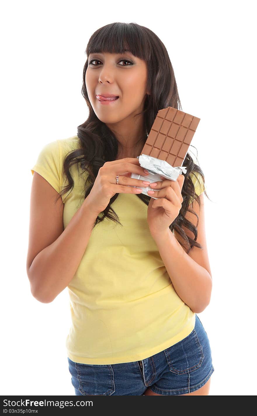 A pretty young beautiful woman holding a chocolate block and licking lips yum. White background. A pretty young beautiful woman holding a chocolate block and licking lips yum. White background.