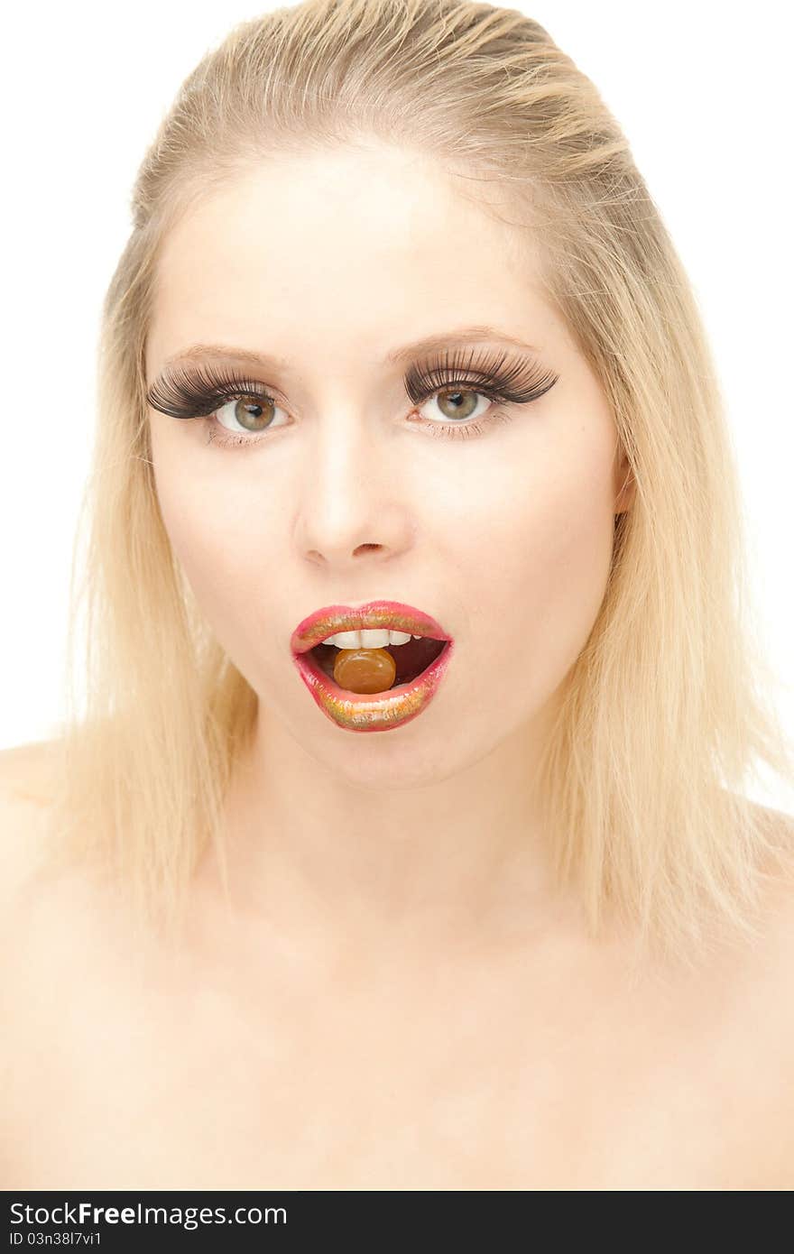 Portrait of attractive Blond woman with lengthen eyelashes and pill in her moth. Portrait of attractive Blond woman with lengthen eyelashes and pill in her moth.