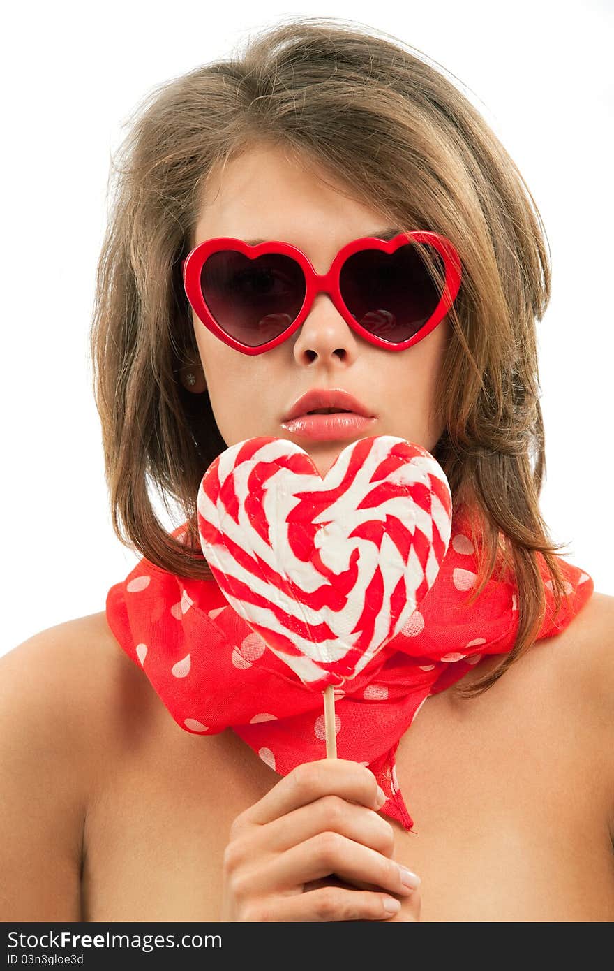 Close-up portrait of young woman with heart shaped lollipop and sunglasses. Close-up portrait of young woman with heart shaped lollipop and sunglasses