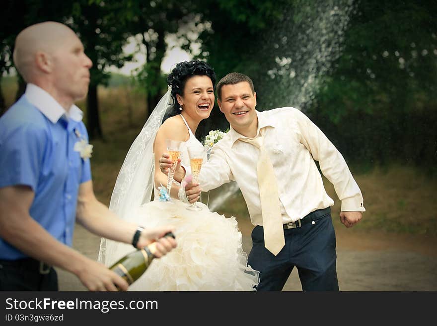 Young man opens sparkling wine and splashing on wedding