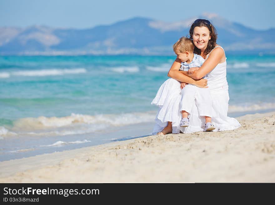 Young Mother With Her Son On Beach Vacation