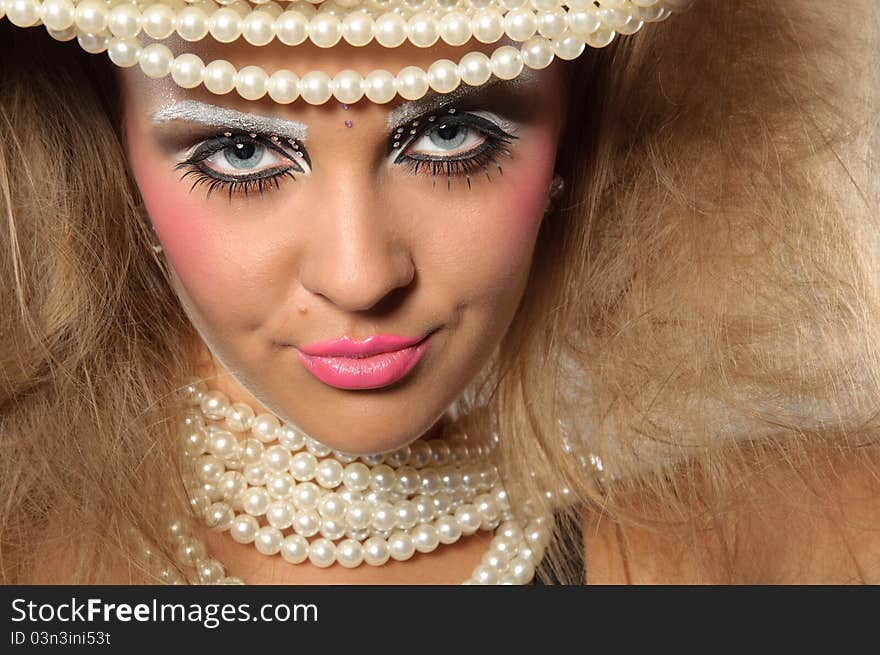 Girl with a professional makeup and pearl beads