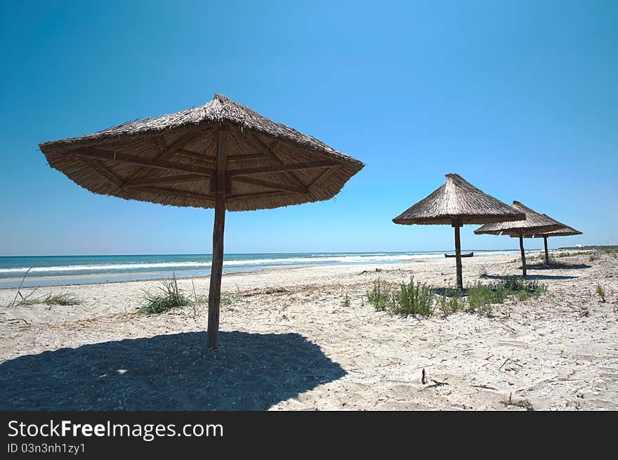 Empty beach with wooden umbrellas