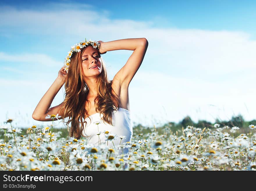 Girl in dress on the daisy flowers field