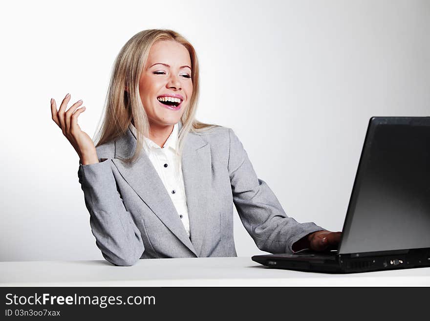 Laughing business woman working on laptop