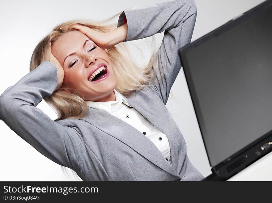 Laughing business woman working on laptop