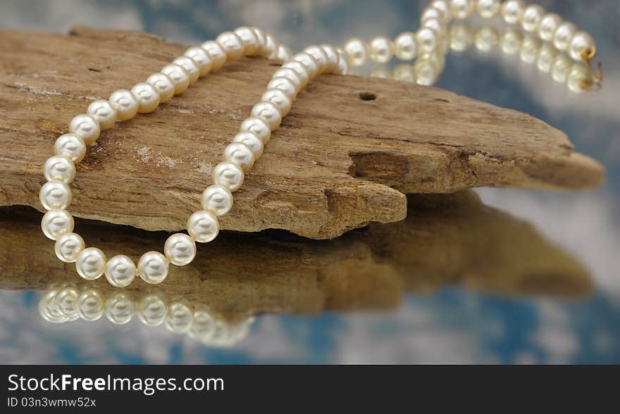 Elegant pearls with sky, drift wood, and reflection very shallow depth of field