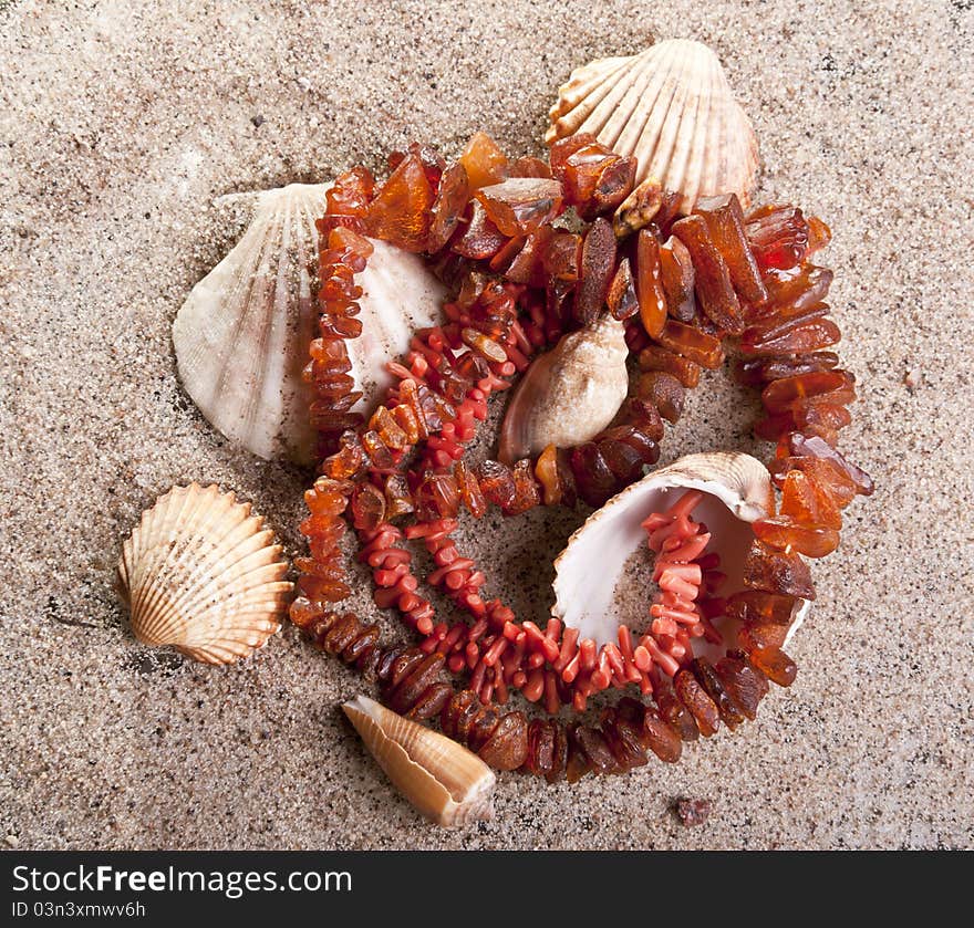 Amber necklace with shells on the beach. Amber necklace with shells on the beach.