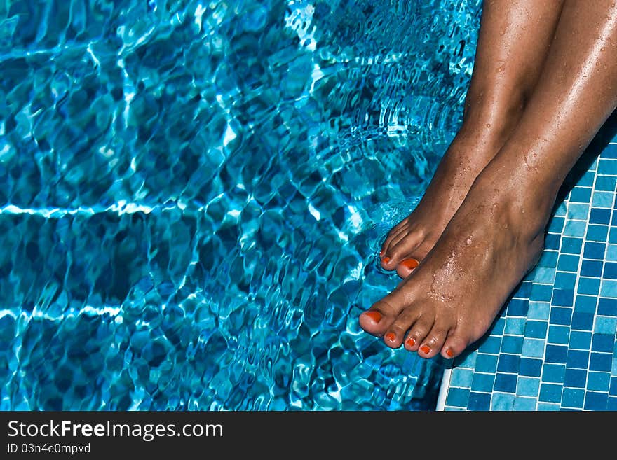 Tanned female feet in the pool. Tanned female feet in the pool