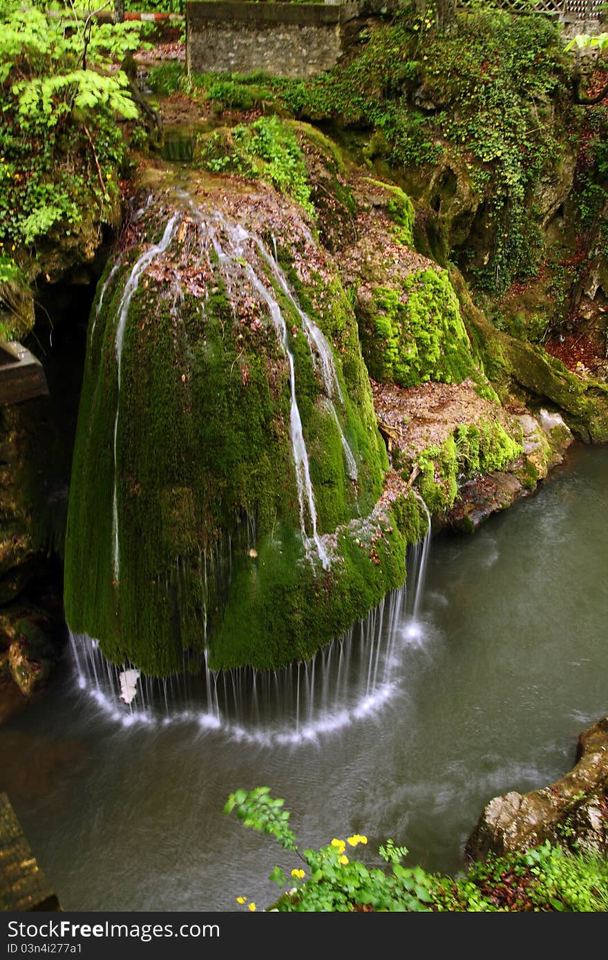 Beautiful waterfall falling off a rock covered with moss