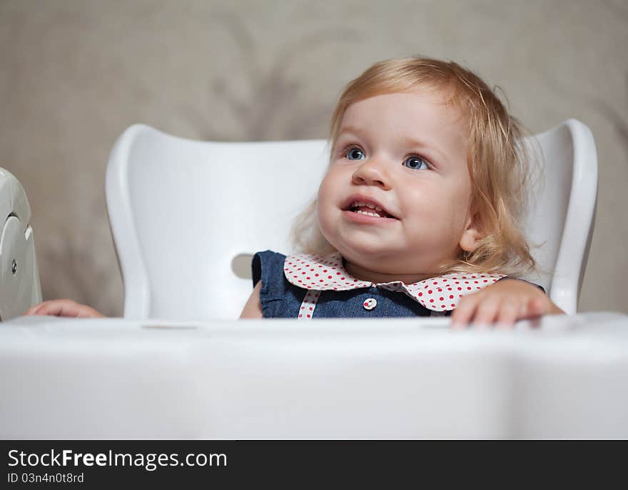 Toddler sitting at the table and looking up. Toddler sitting at the table and looking up