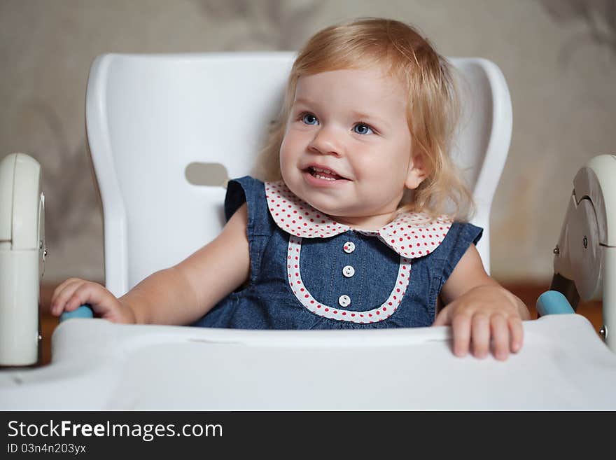 Little girl sitting at the table and looking left