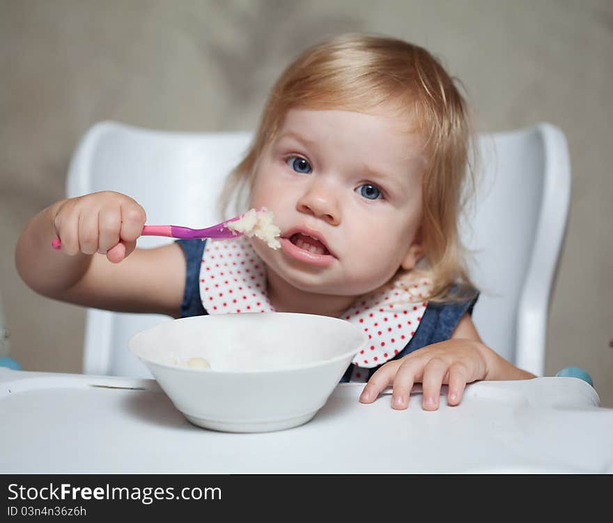 Little girl eating porridge