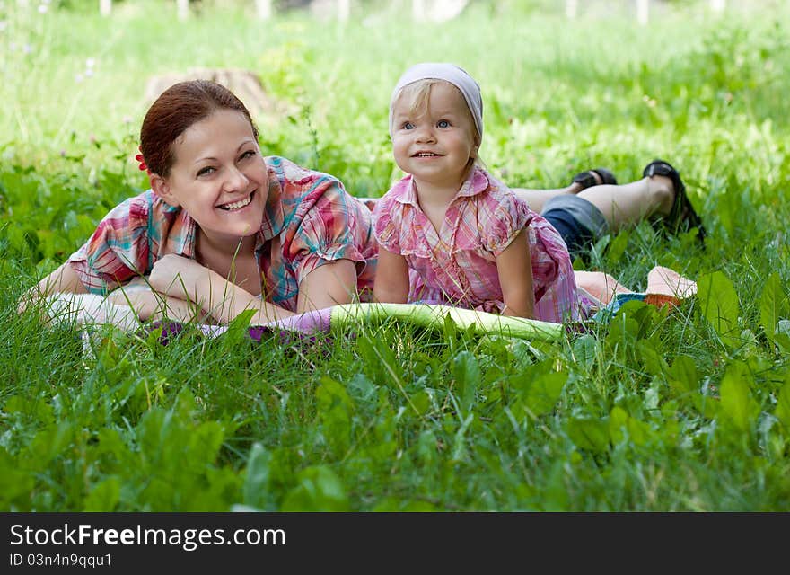 Mother and daughter lying in the grass