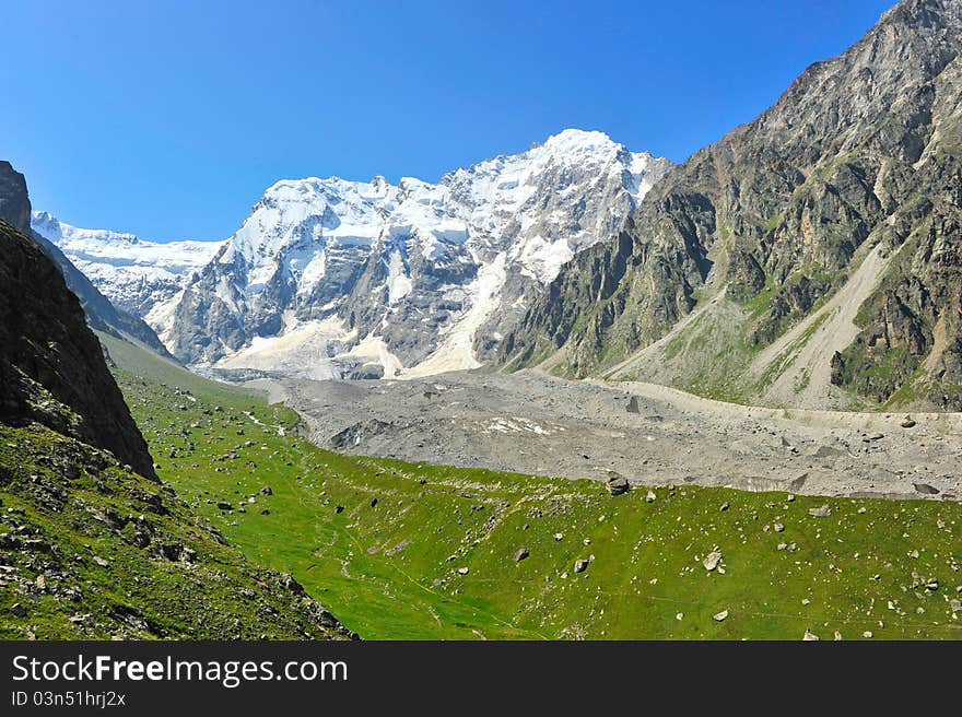 Mountain landscape with green field and stones