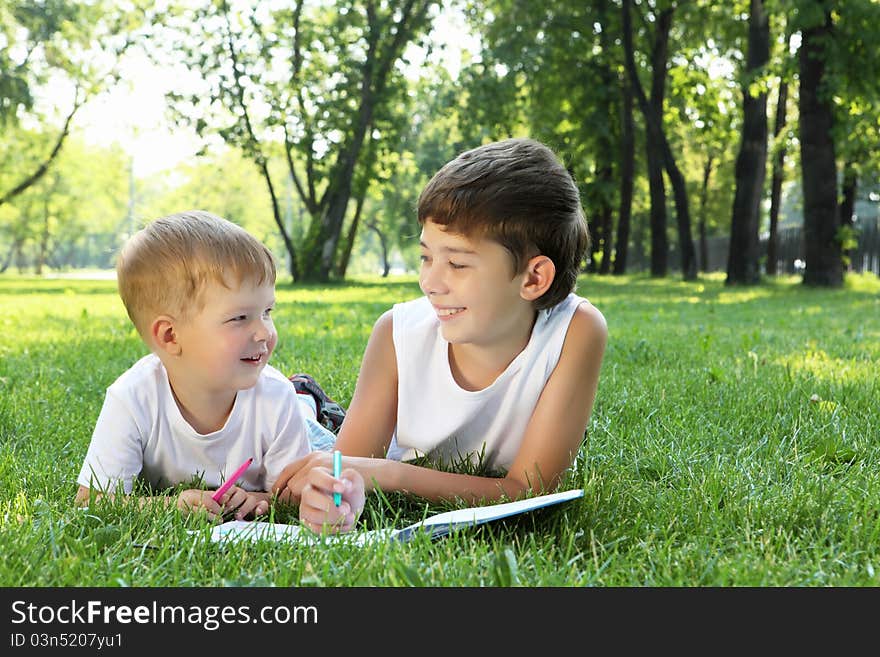 Children in the park reading a book